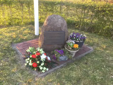 Herdenkingsplek Tweede Wereldoorlog met een kei en bloemen
