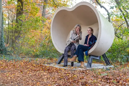 Twee mensen op een bijzonder bankje in het bos